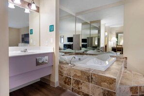 A modern bathroom with a large mirror, a vanity with a sink, a bathtub, and a shower area.