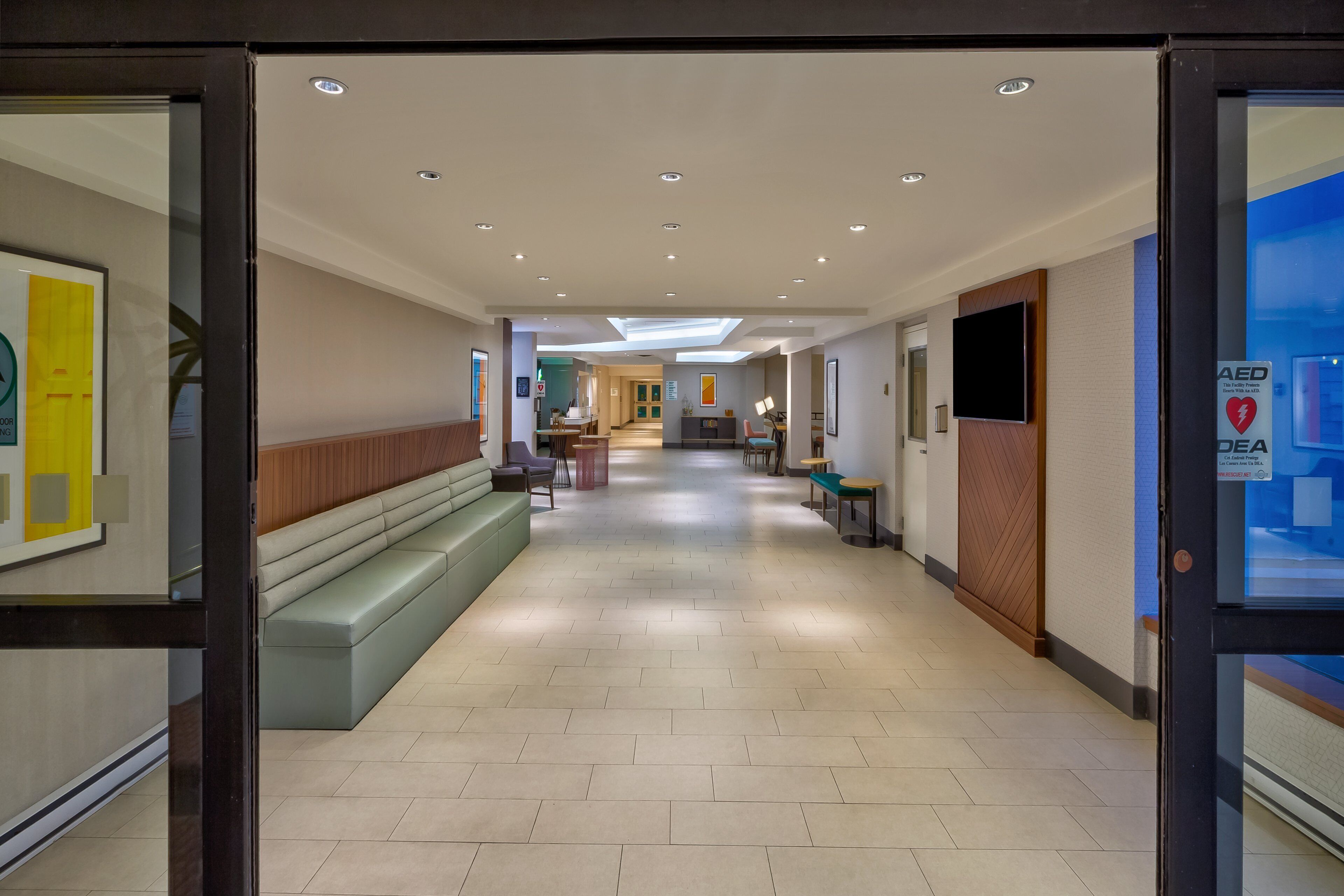 Un lobby moderno de hotel con mostrador de recepción, zona de estar y acceso despejado a los ascensores.