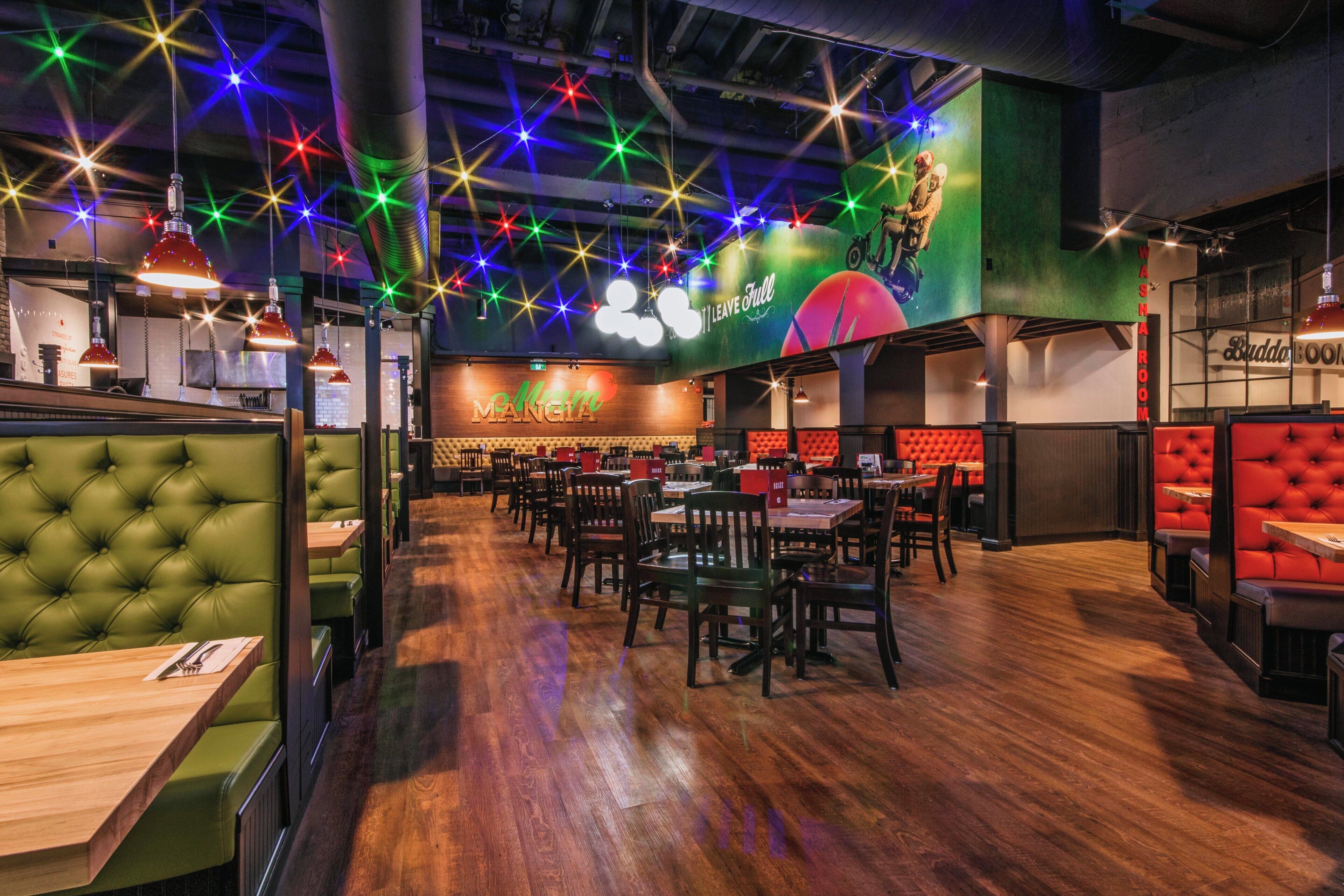 A restaurant interior with booths, tables, and a bar area.