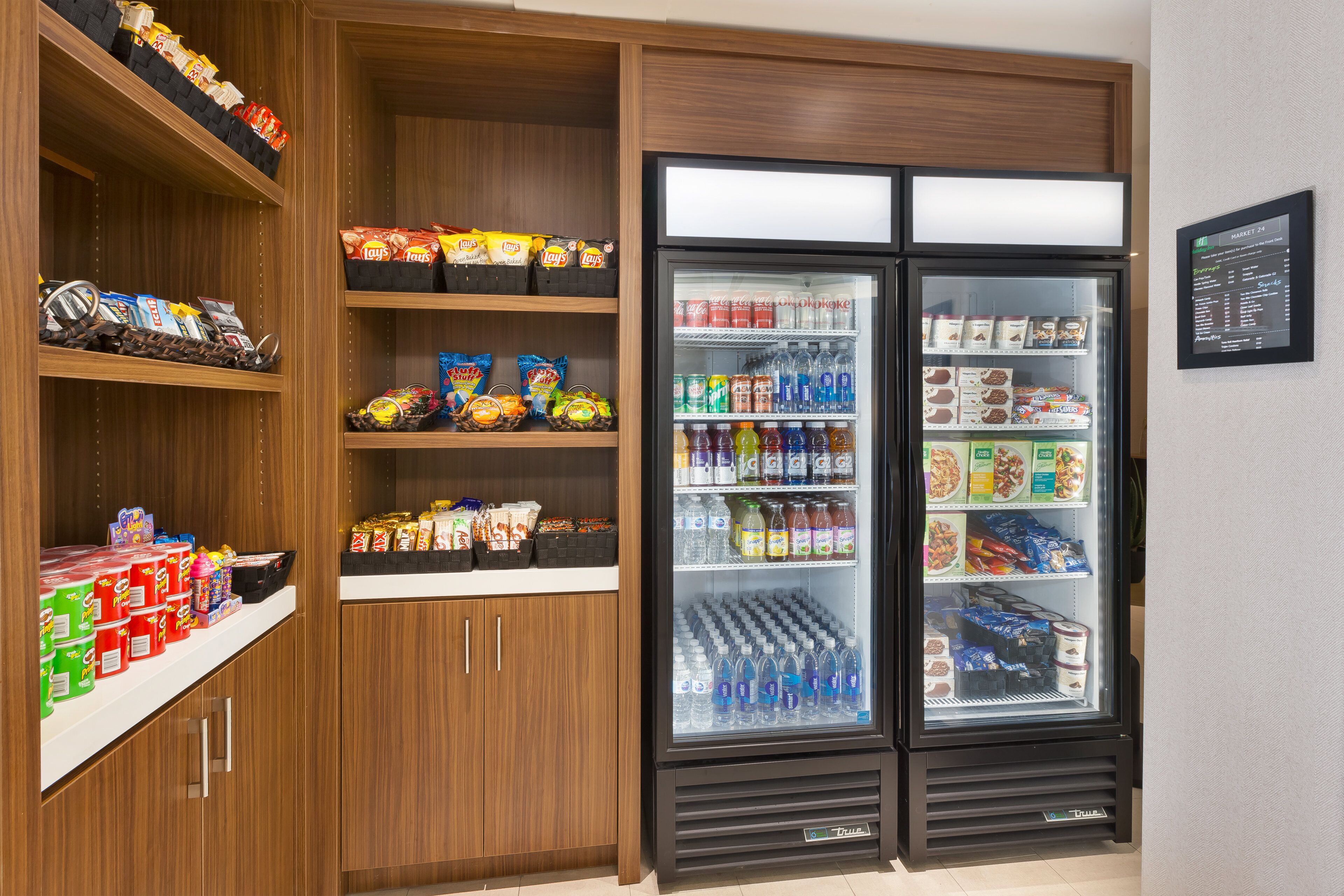 Una máquina expendedora llena de aperitivos y bebidas, y un refrigerador con diferentes alimentos.