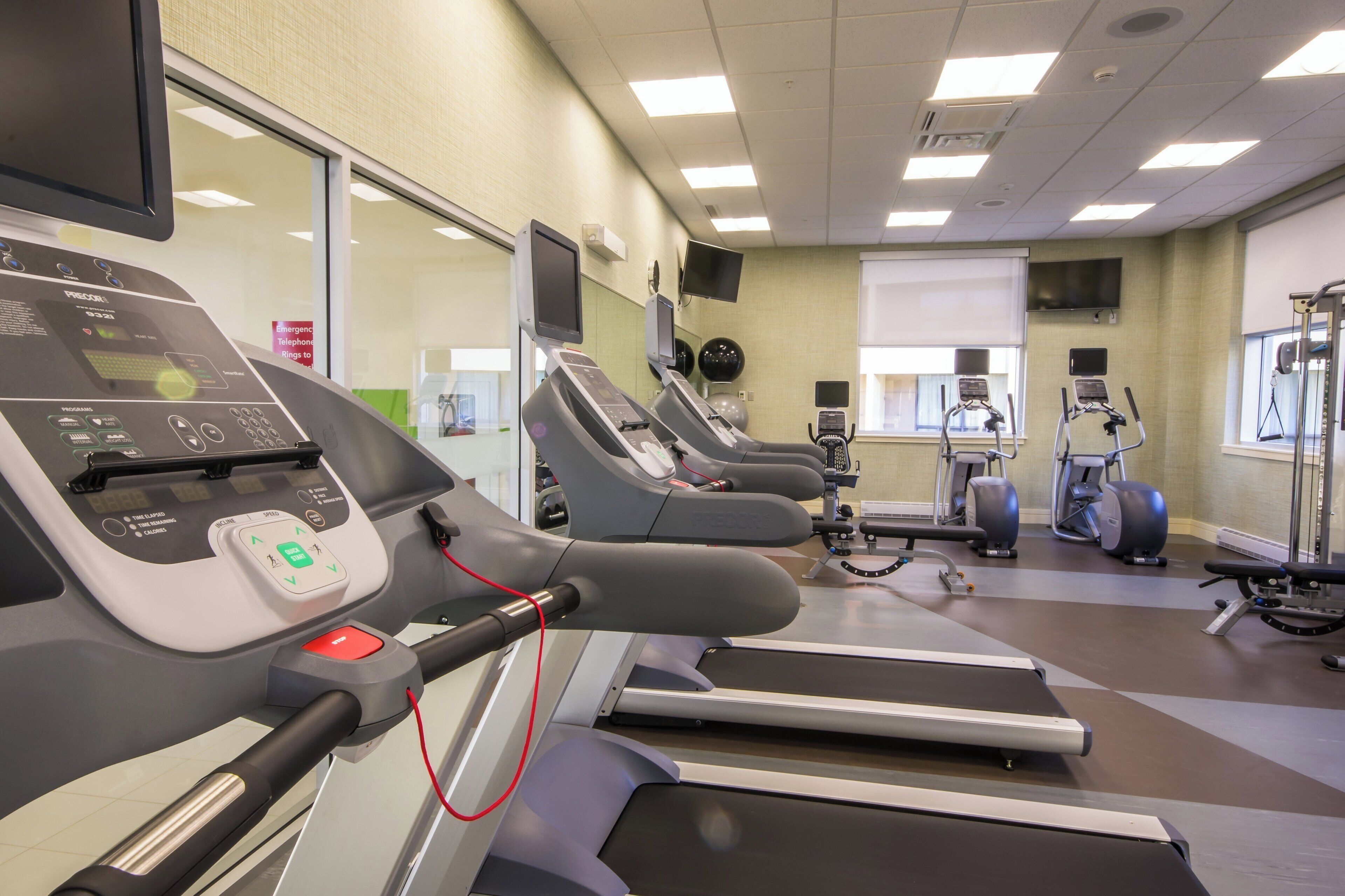 A fitness center with treadmills, exercise balls, and weight machines.