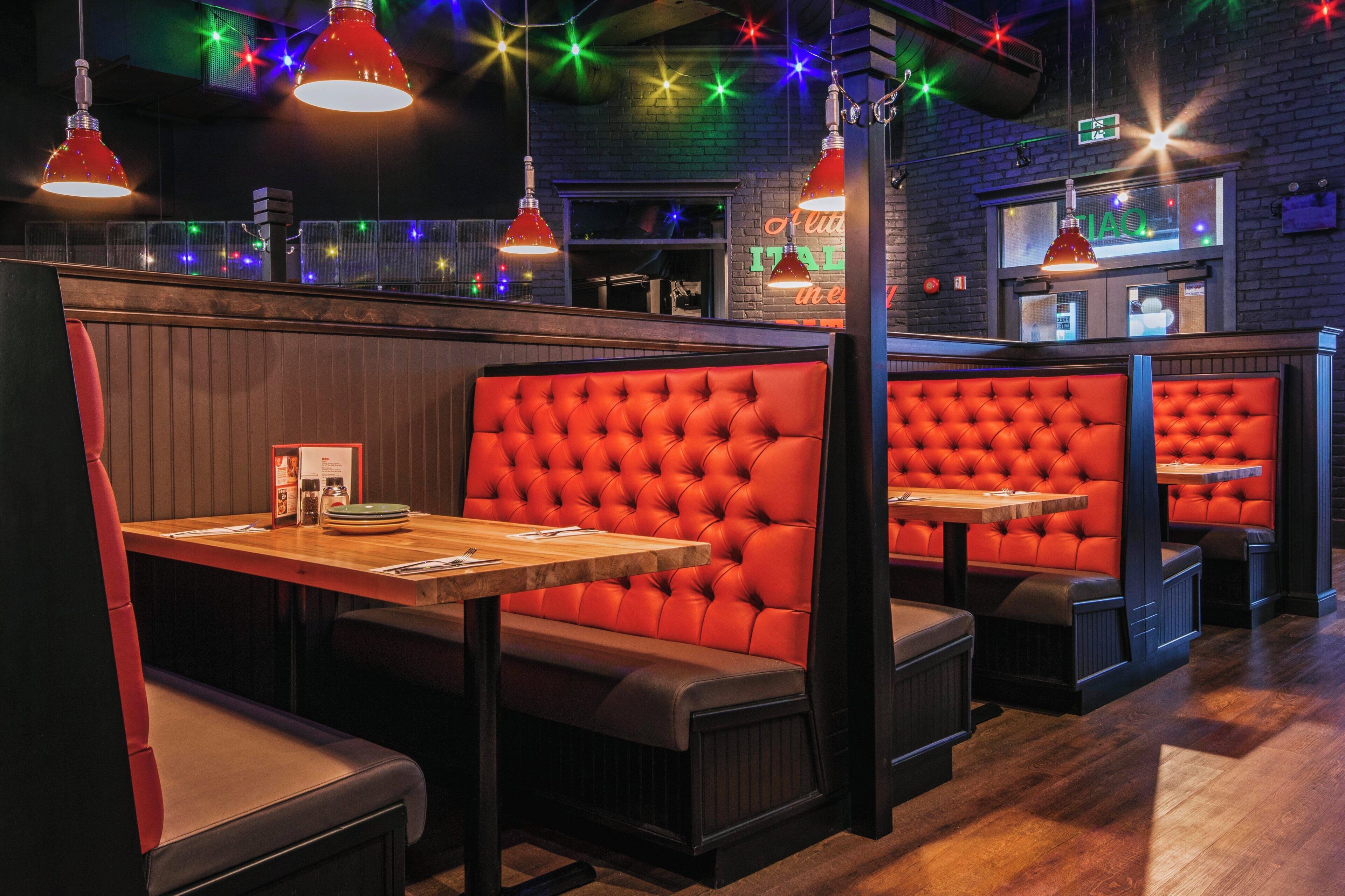 A restaurant interior with booths, wooden tables, and red upholstered seating.