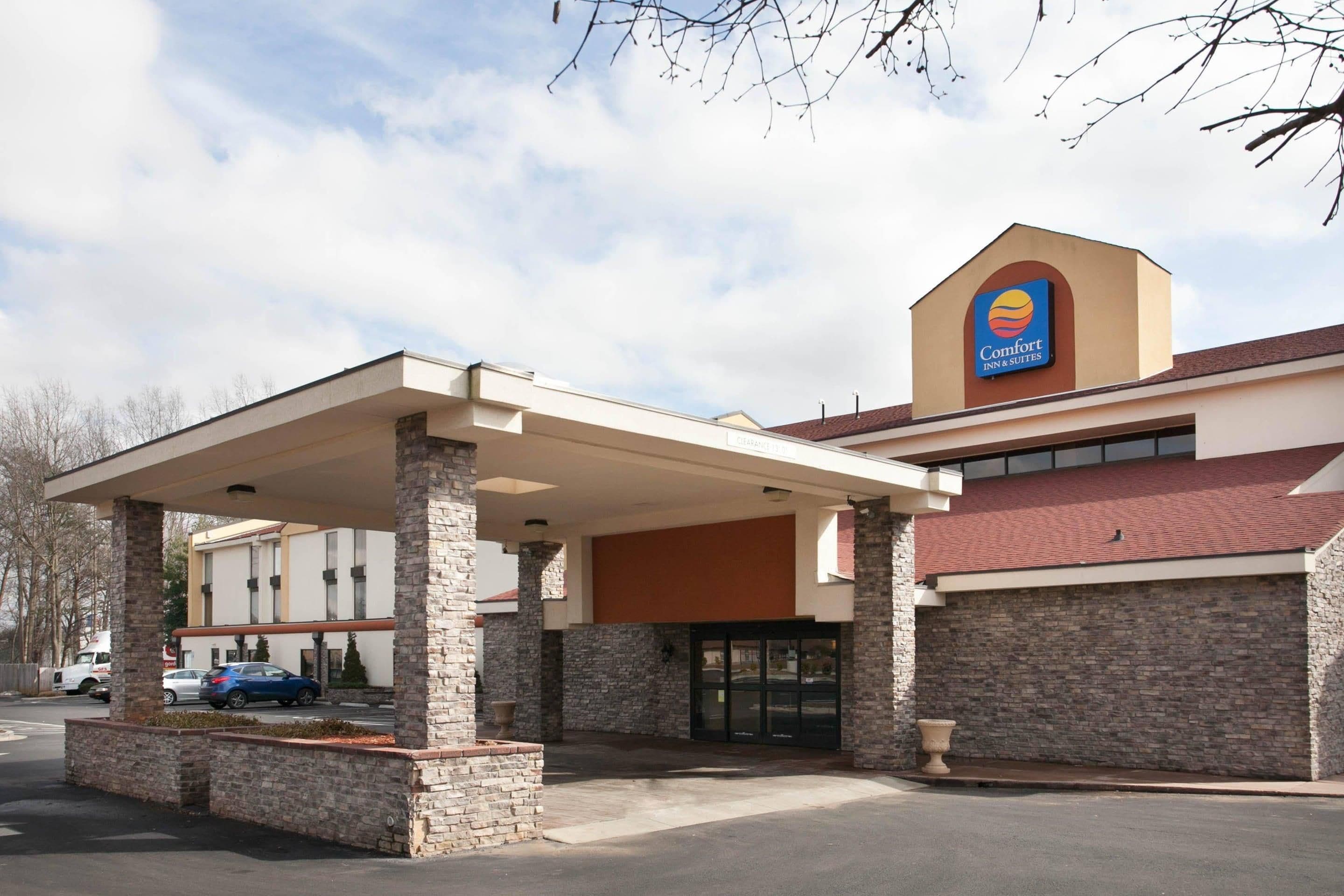 A Comfort Inn & Suites with a covered parking area and a brick facade.