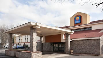A Comfort Inn & Suites with a covered parking area and a brick facade.