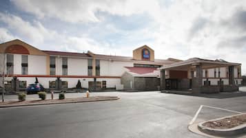 A Comfort Inn & Suites hotel with a parking lot, a covered entrance, and a clear sky.
