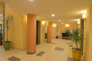 A hotel lobby with large pillars, potted plants, and a reception area. - Comfort Inn & Suites Statesville - Mooresville (Statesville)