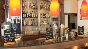 A bar area with a variety of liquor bottles, a selection of glasses, and a sign indicating a whiskey selection.