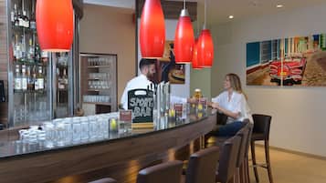 Un espace bar avec un comptoir, des verres et des bouteilles.