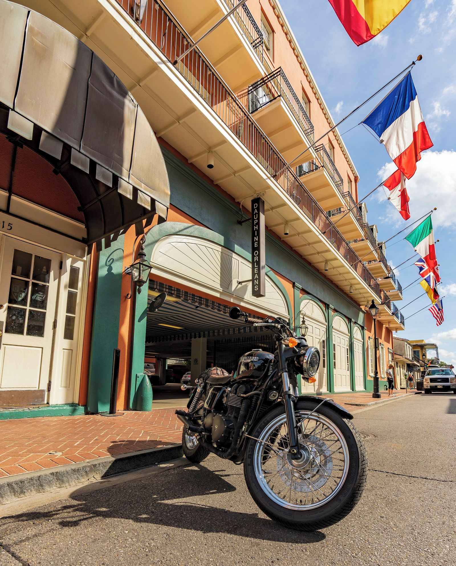 Une moto est garée devant un immeuble sur lequel on peut lire l’inscription « DAUPHINE ORLEANS ».