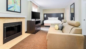 A hotel room with a fireplace, a television, a bed, and a sofa. - Residence Inn by Marriott Boston North Shore/Danvers (Danvers)