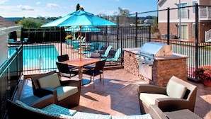 A patio with wicker furniture, a barbecue grill, and a pool area. - Residence Inn by Marriott Boston North Shore/Danvers (Danvers)