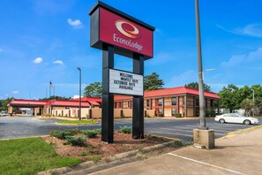 A hotel sign with a red roof and a welcoming message.