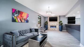 A modern living room with a grey sofa, a coffee table, and a fireplace.