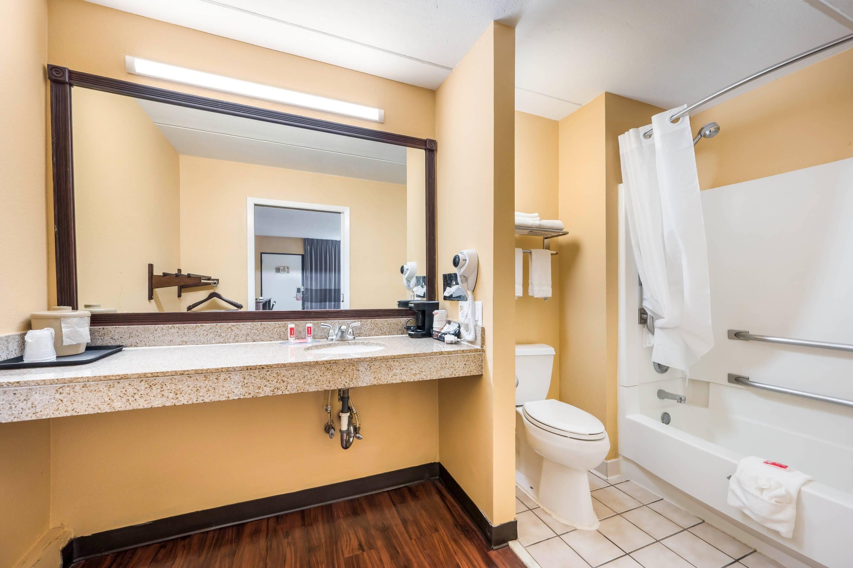 A hotel bathroom with a sink, toilet, and shower.