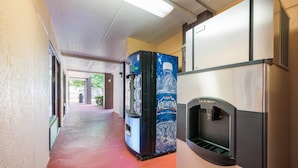 Un pasillo con dispensador de agua y máquina expendedora.
