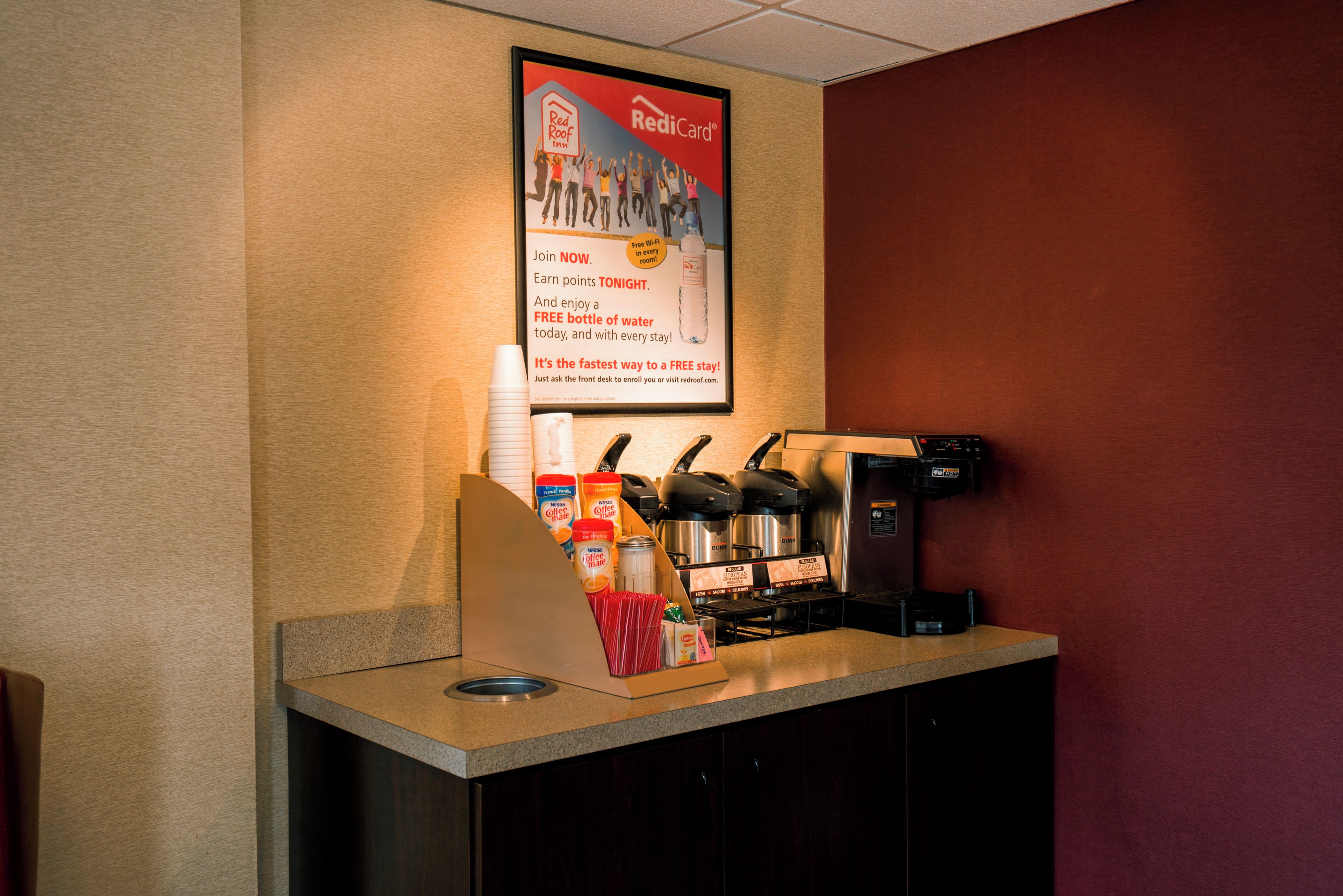 A Red Roof Inn sign with a RediCard logo, a coffee machine, and a water dispenser.