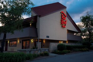A Red Roof Inn with a prominent neon sign, a stone facade, and a balcony. - Red Roof Inn Rockford East – Casino District (Rockford)
