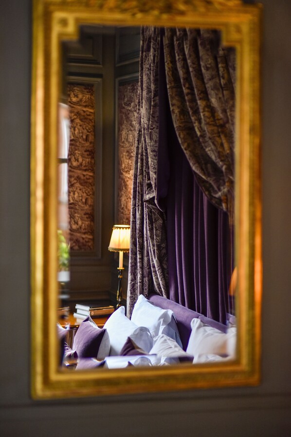 A room with a bed, a lamp, and a mirror reflecting the bed and curtains. - San Domenico House (London)