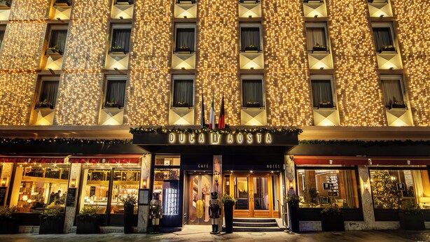 A hotel facade with illuminated lights, a cafe, and a hotel entrance. - Hotel Duca D'Aosta (Aosta)