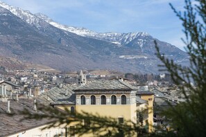 Un pueblo con una iglesia destacada, montañas nevadas al fondo y una mezcla de edificios tradicionales y modernos.