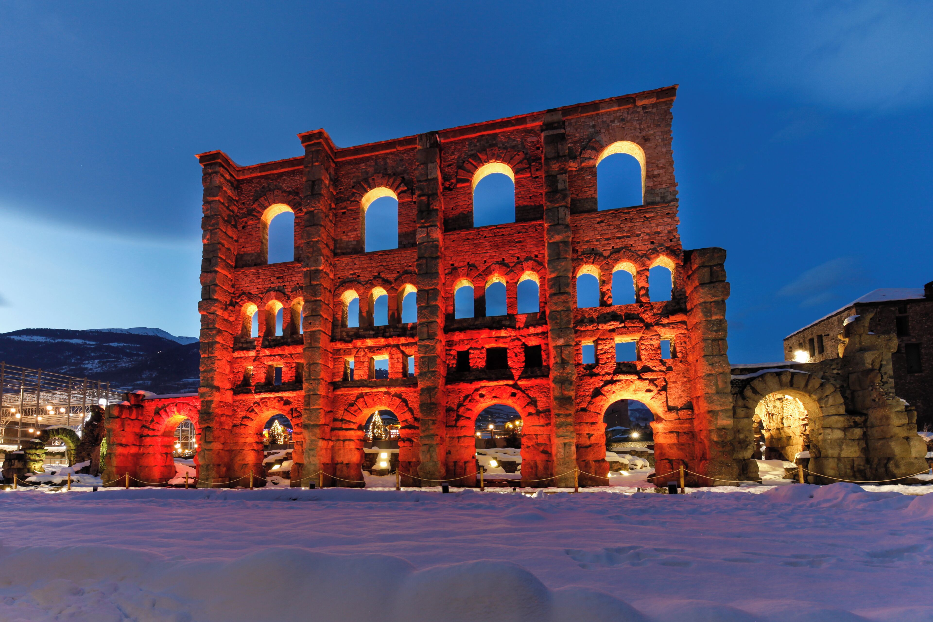 A historic building with multiple arches and a snow-covered foreground.