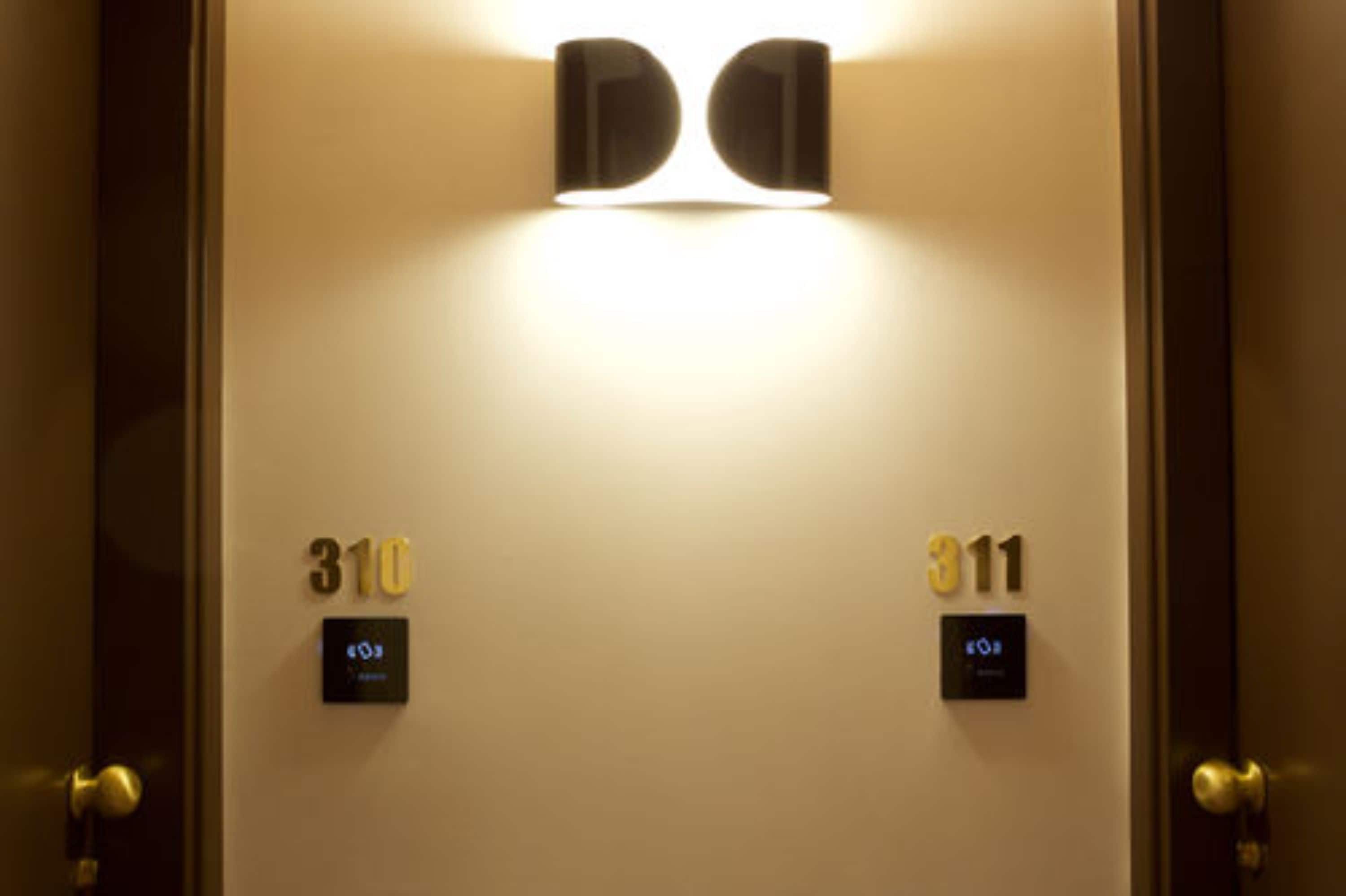 A hotel room entrance with two doors labeled 310 and 311, each with a digital keycard reader.