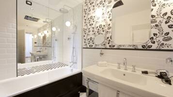 Une salle de bain moderne dotée d’un grand miroir, d’un double vasque et d’un espace douche.
