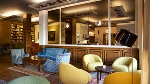 A cozy library with bookshelves, comfortable seating, and a large mirror reflecting the room. - Hotel Duca D'Aosta (Aosta)