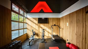 Un gimnasio con paredes de madera, un gran logotipo rojo en el techo y diverso equipo de ejercicio.