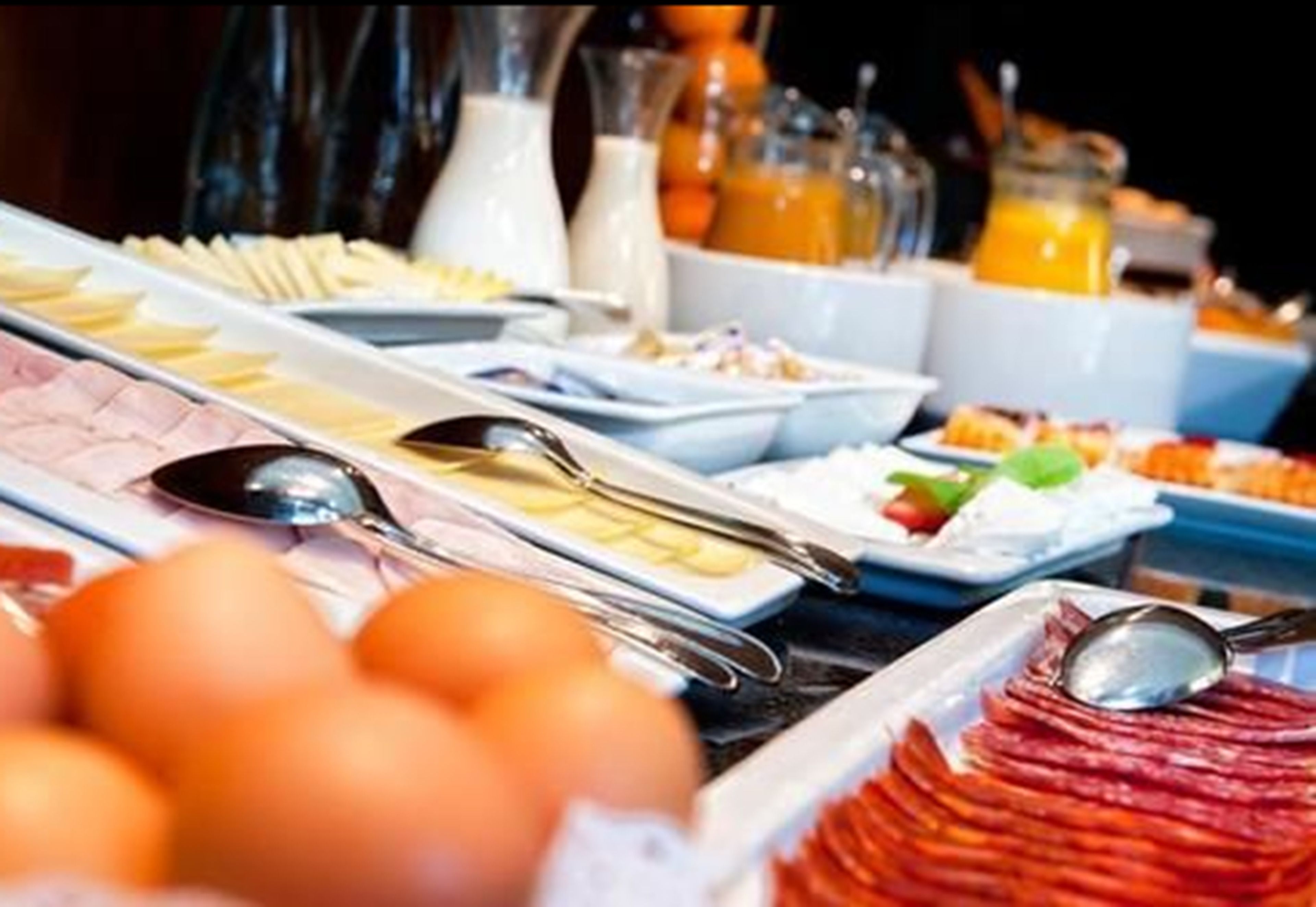 A buffet with various food items and utensils.