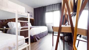 Een hotelkamer met stapelbedden, een bureau en een stoel.