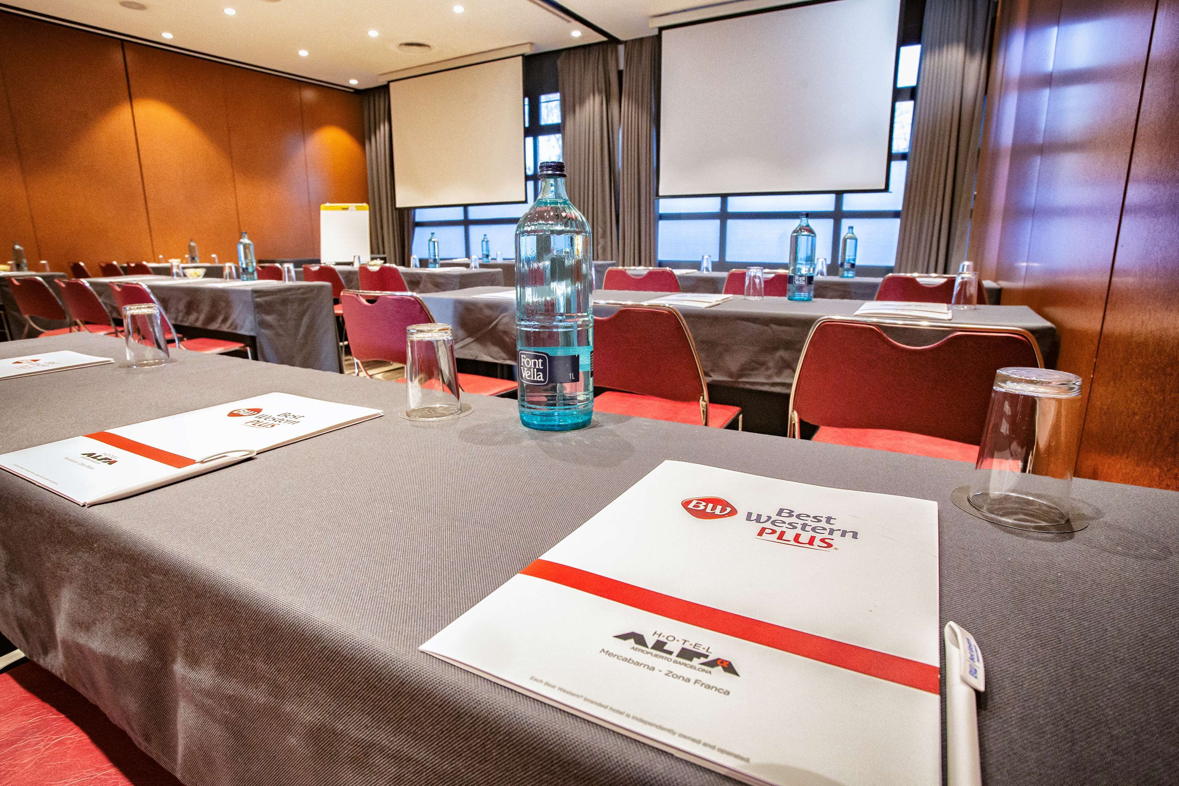 A conference room with tables set for a meeting, water bottles, and nameplates.