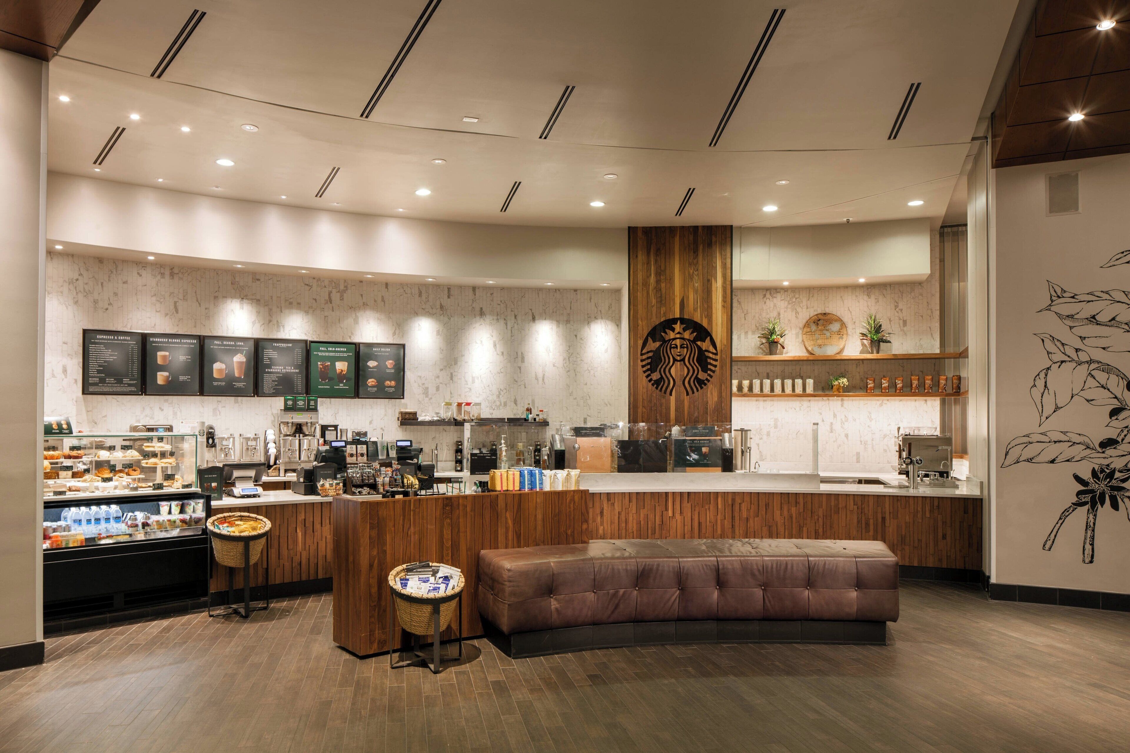 A modern coffee shop with a wooden counter, seating area, and menu boards.