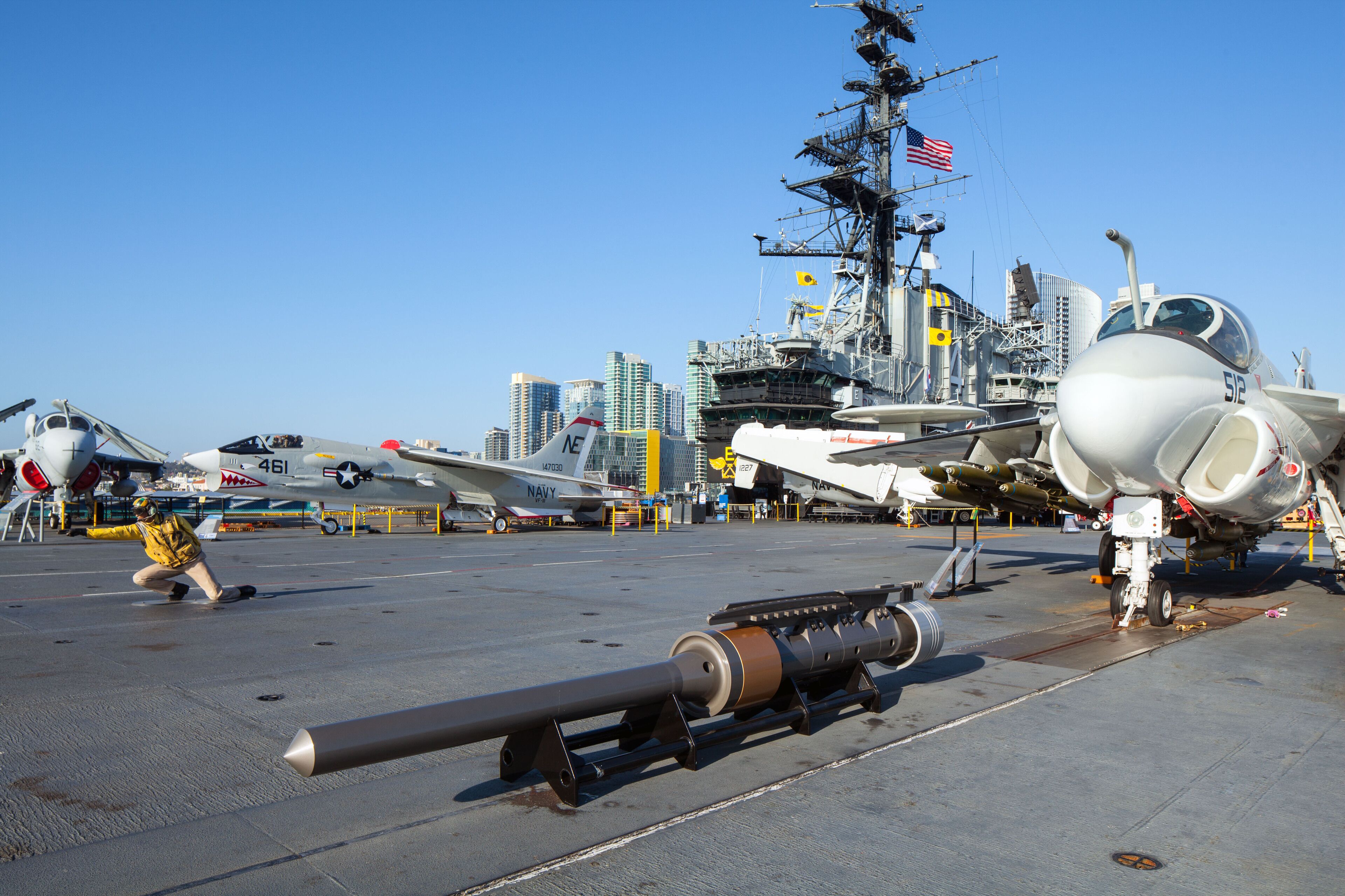 A naval aircraft carrier with multiple aircraft, including a fighter jet and a bomber, docked.