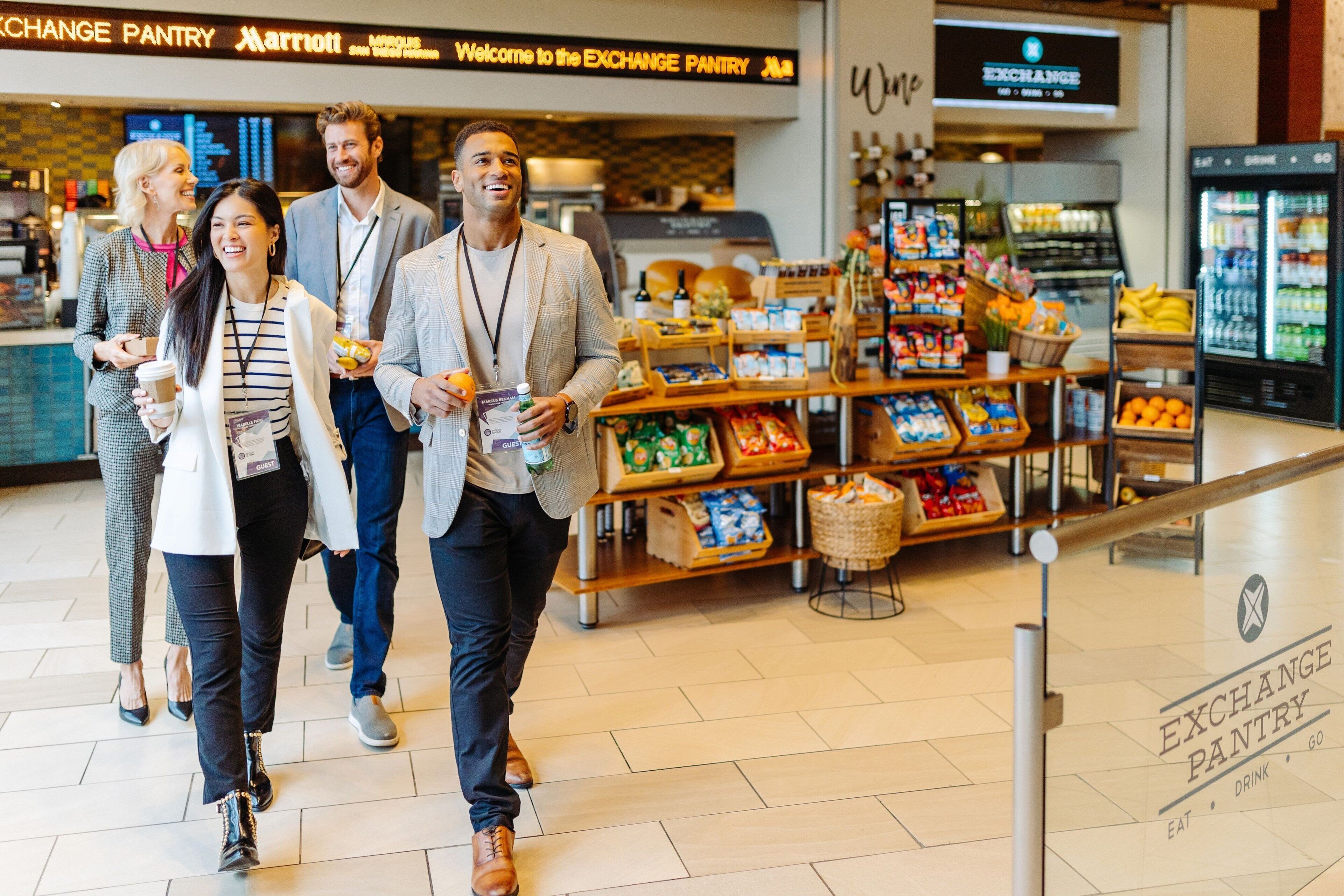 A group of people walking in a modern building with a visible sign for the Exchange Pantry.