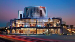 Un hotel moderno con una destacada torre circular y fachada de vidrio.