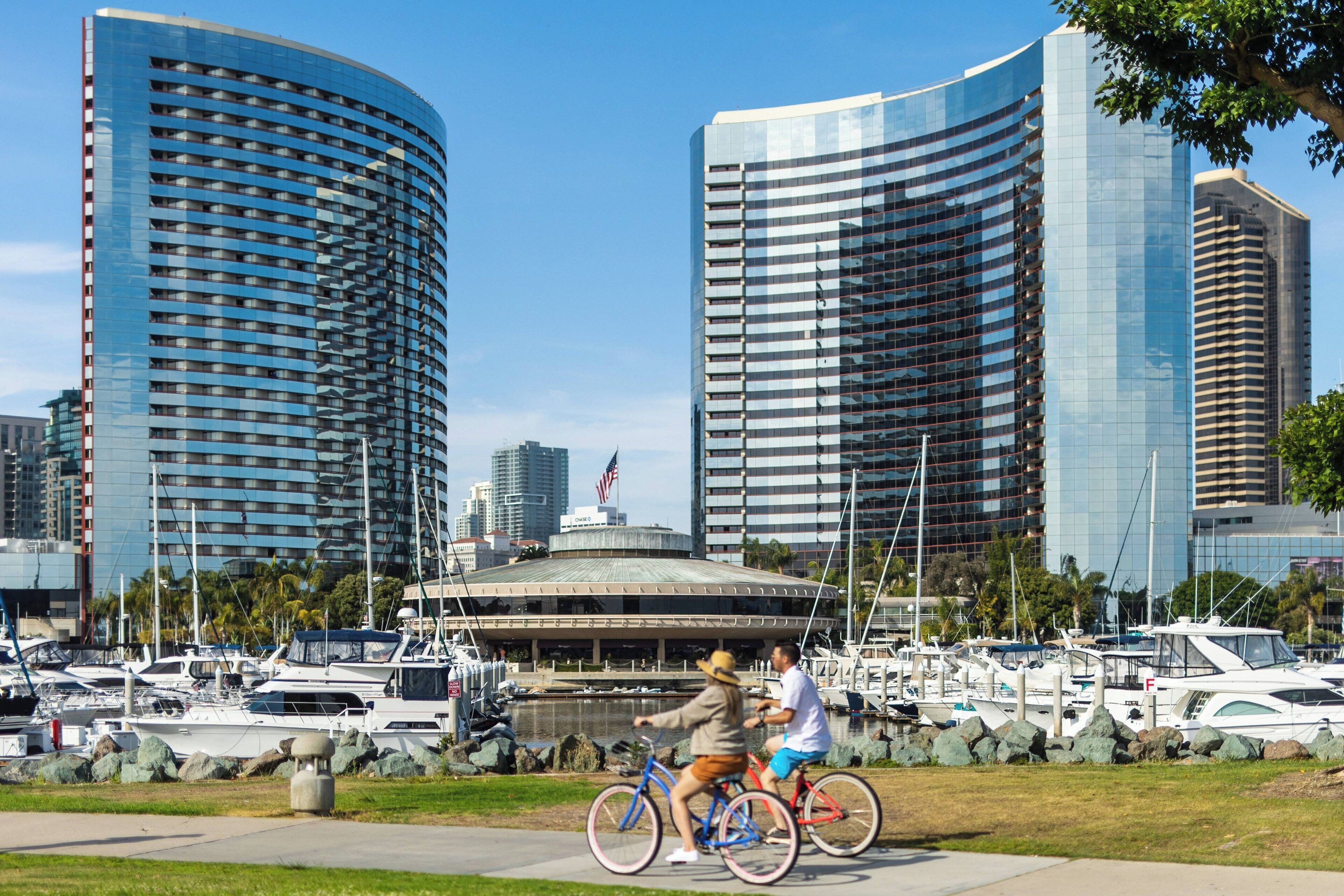 A marina with boats and a large building with a curved facade.