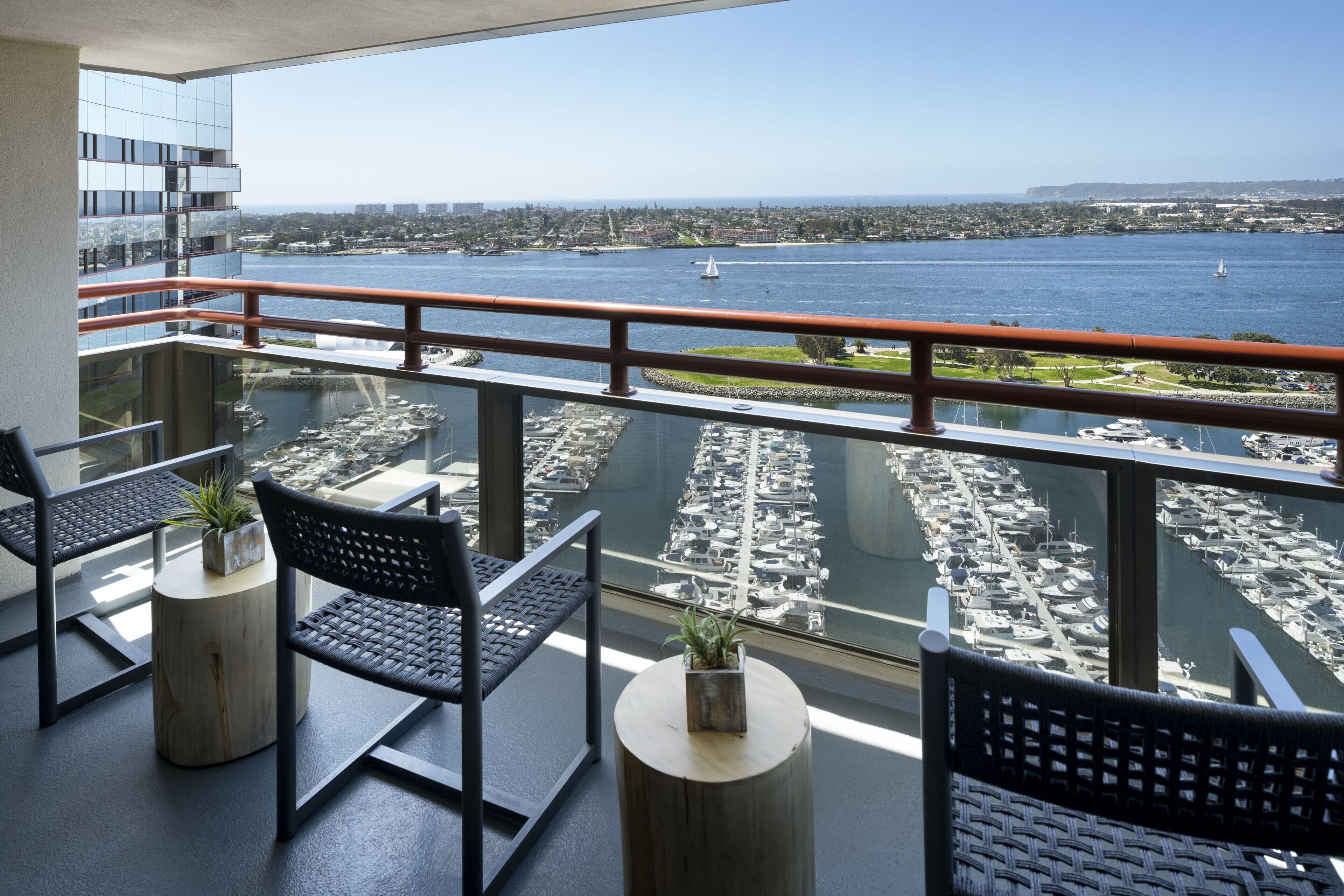 A balcony with a view of a marina and cityscape.