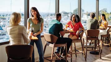 A group of people dining at a restaurant with a view of the marina.