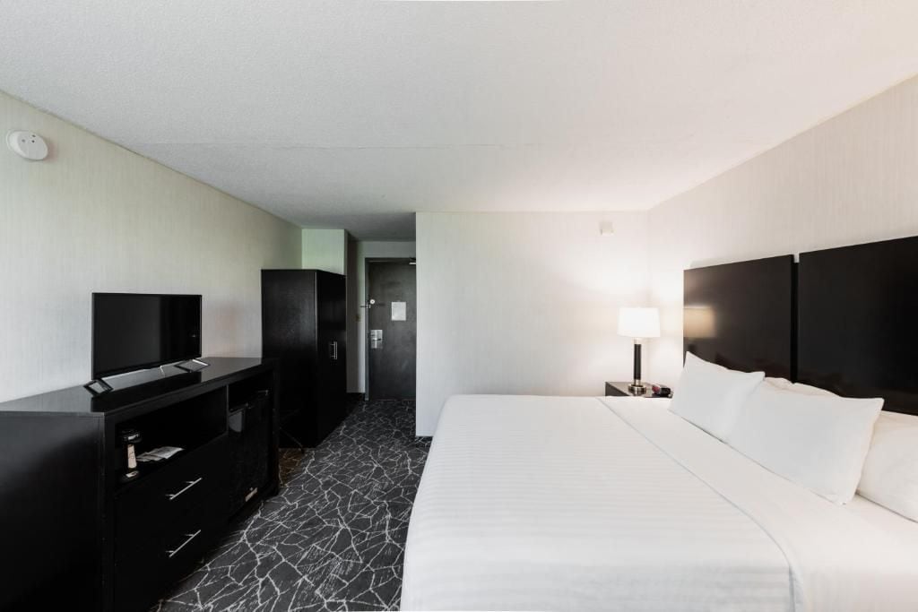 A hotel room with a bed, a TV, a desk, and a wardrobe.