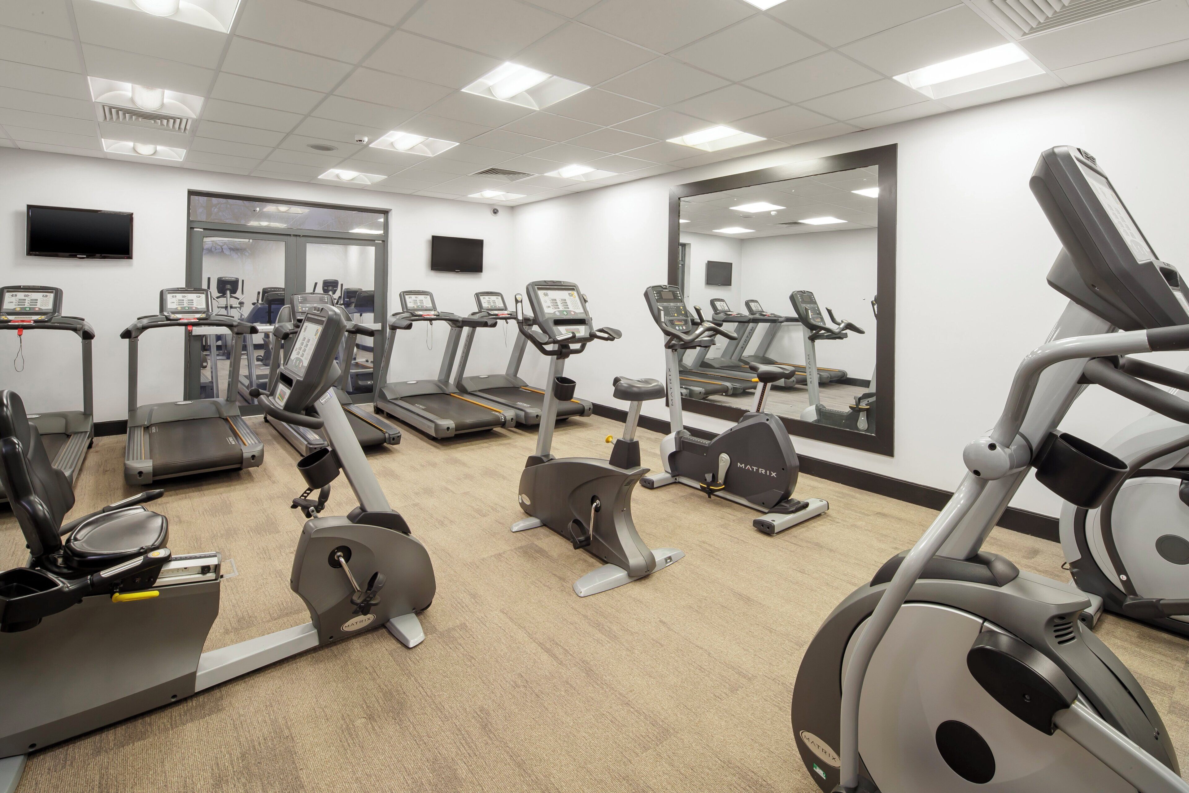 A gym with multiple treadmills, stationary bikes, and exercise equipment.
