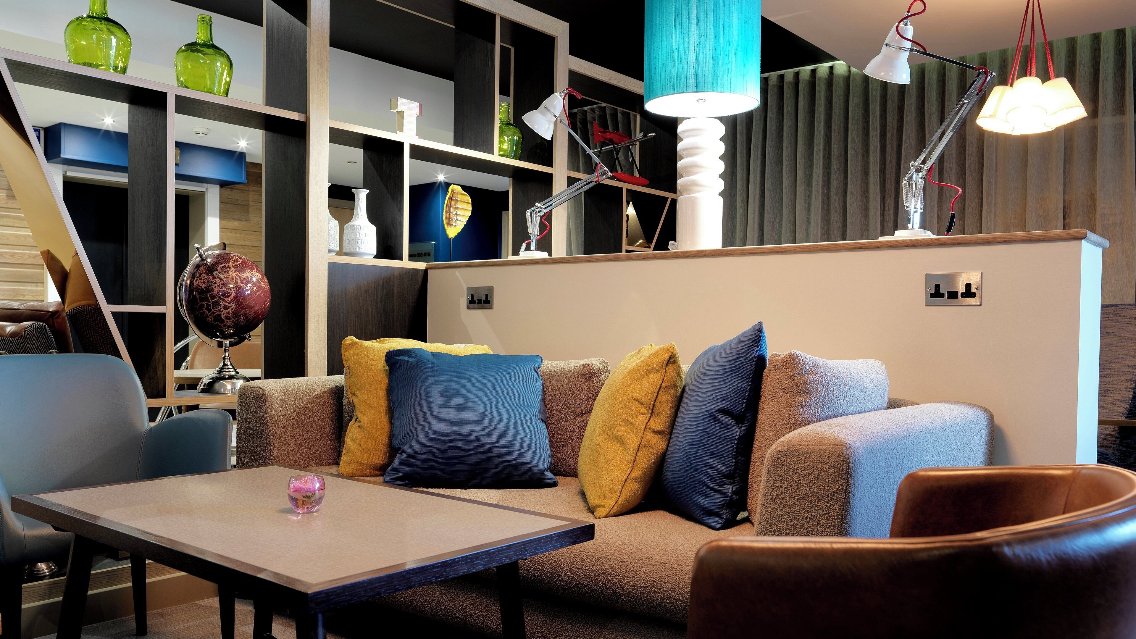 Una sala de estar moderna con un sofá, una mesa de centro y una lámpara.