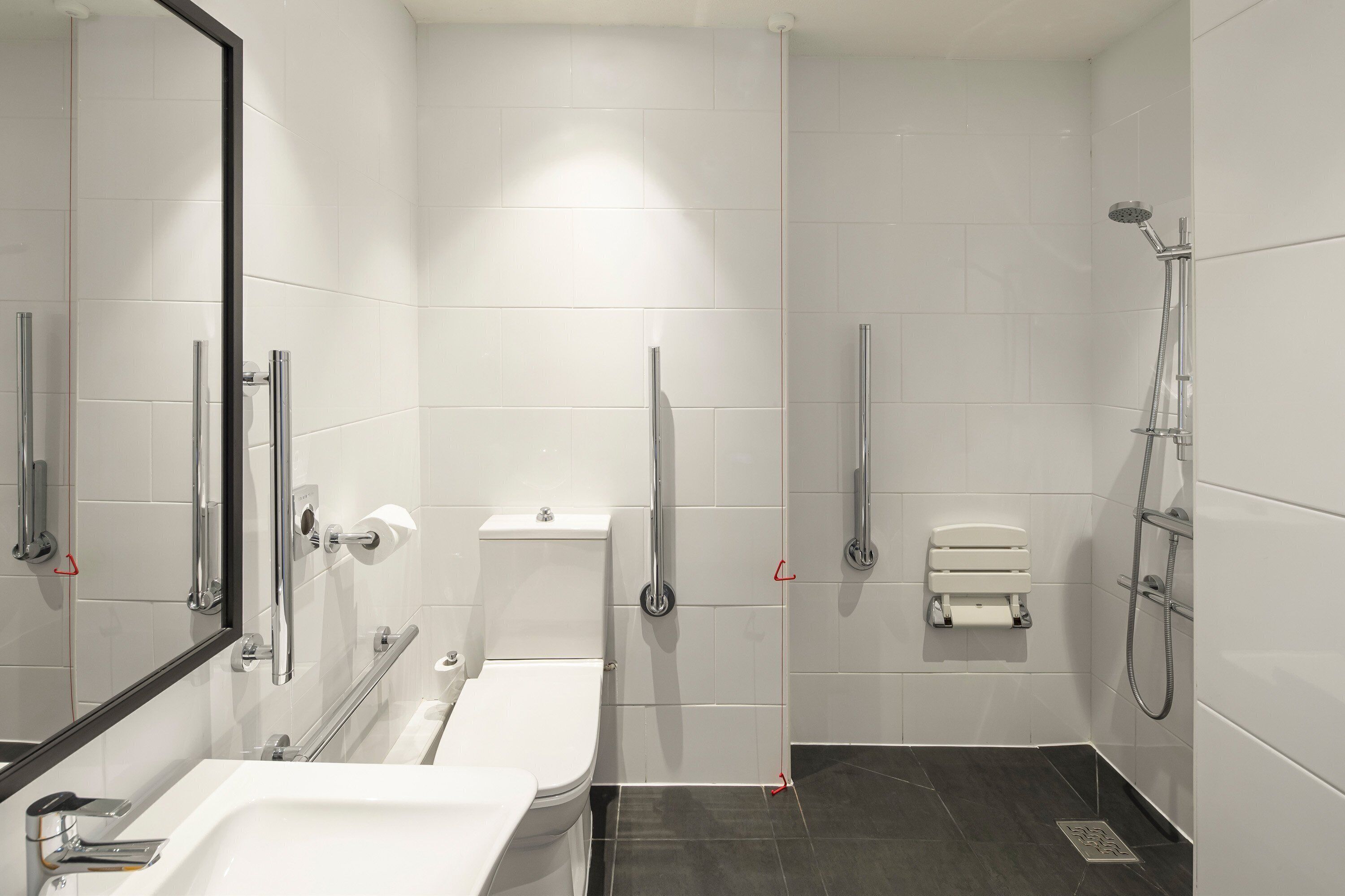 A modern bathroom with a bathtub, toilet, and shower.