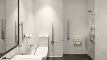 A modern bathroom with a bathtub, toilet, and shower.