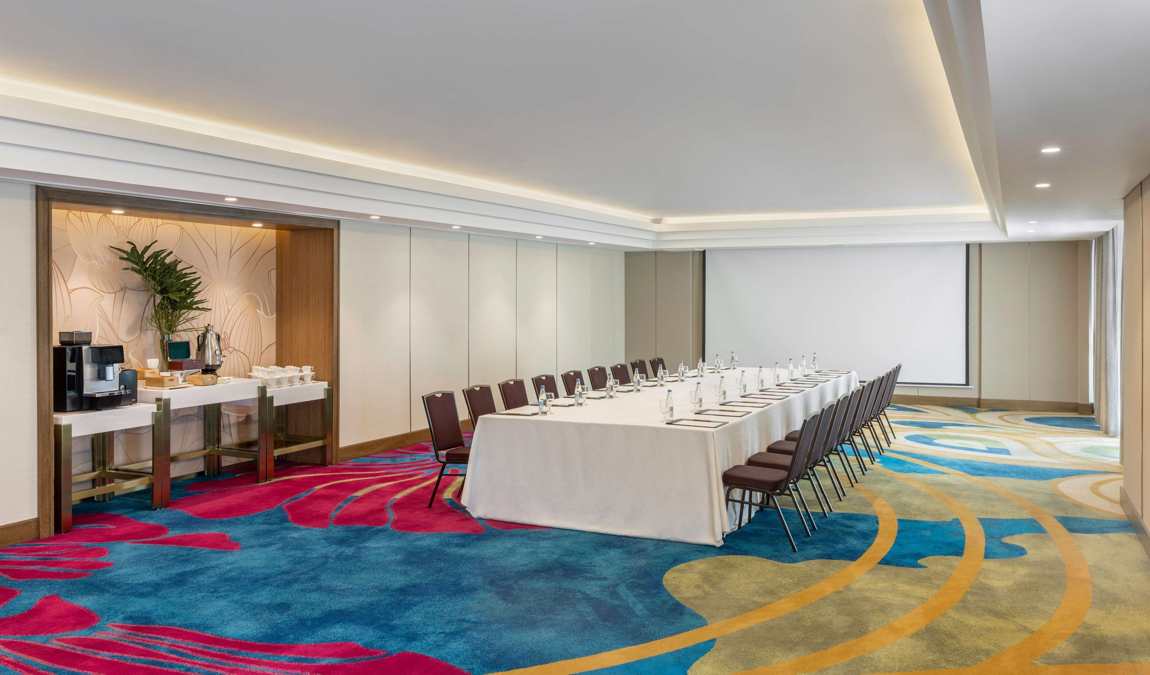 Une salle de conférence équipée d’une longue table, de chaises et d’un coin café.