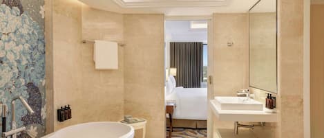 Ein modernes Badezimmer mit einer großzügigen Badewanne, einer separaten Duschkabine und einem Waschtisch mit Spiegel.