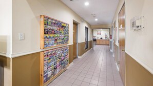 A hallway with two magazine racks, a tiled floor, and a door at the end. - Econo Lodge Inn & Suites Knoxville East (Knoxville)