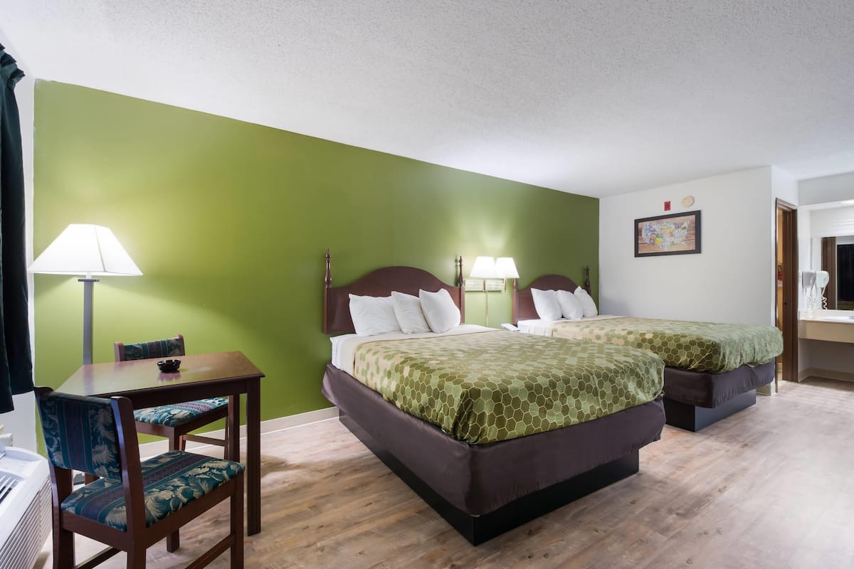 Une chambre d’hôtel avec deux lits, un bureau et une chaise.