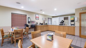 A hotel room with a dining area, kitchenette, and a door leading to the outside. - Econo Lodge Inn & Suites Knoxville East (Knoxville)