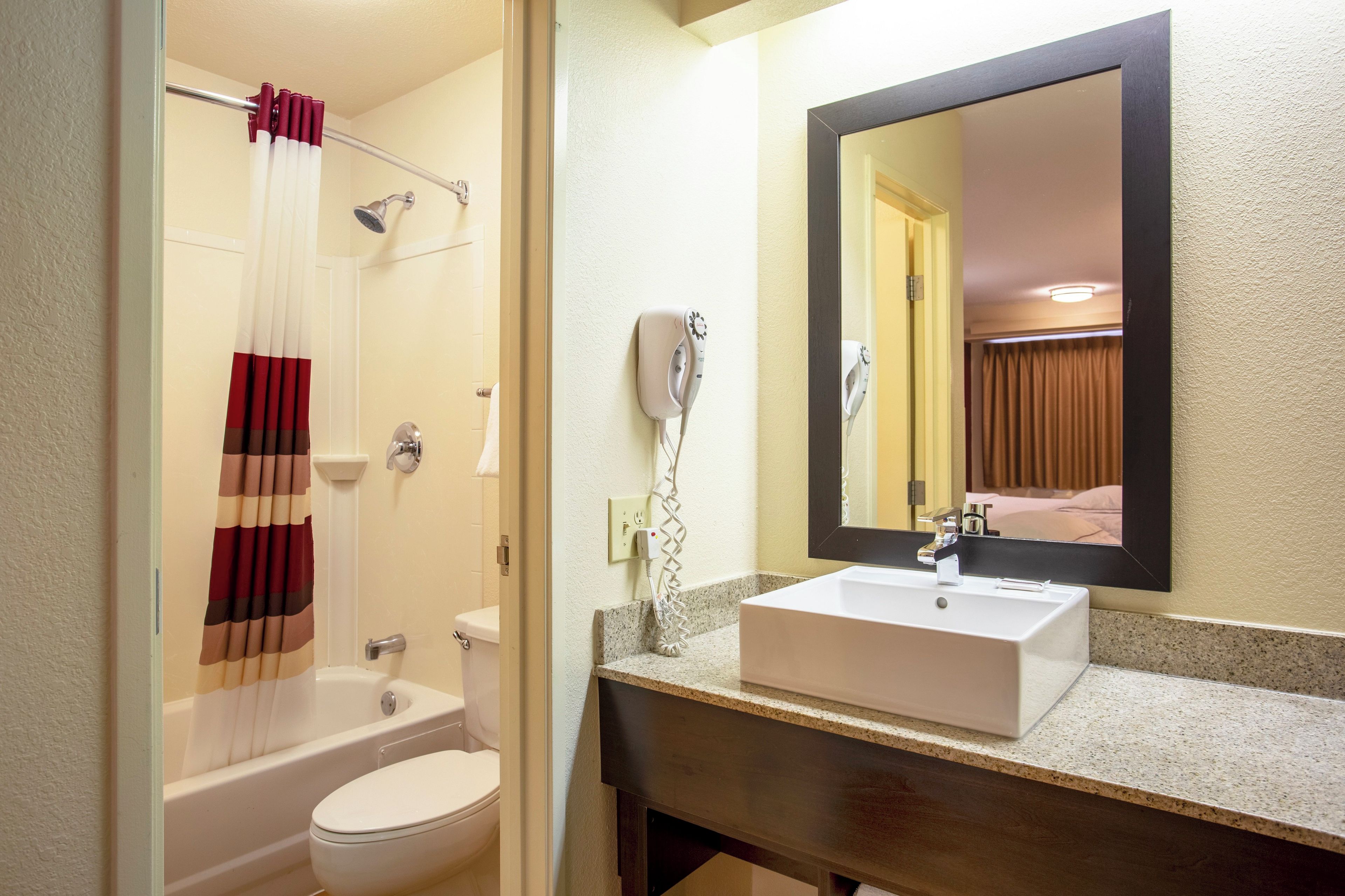 Une salle de bain avec une baignoire, des toilettes et un lavabo avec un miroir au-dessus.